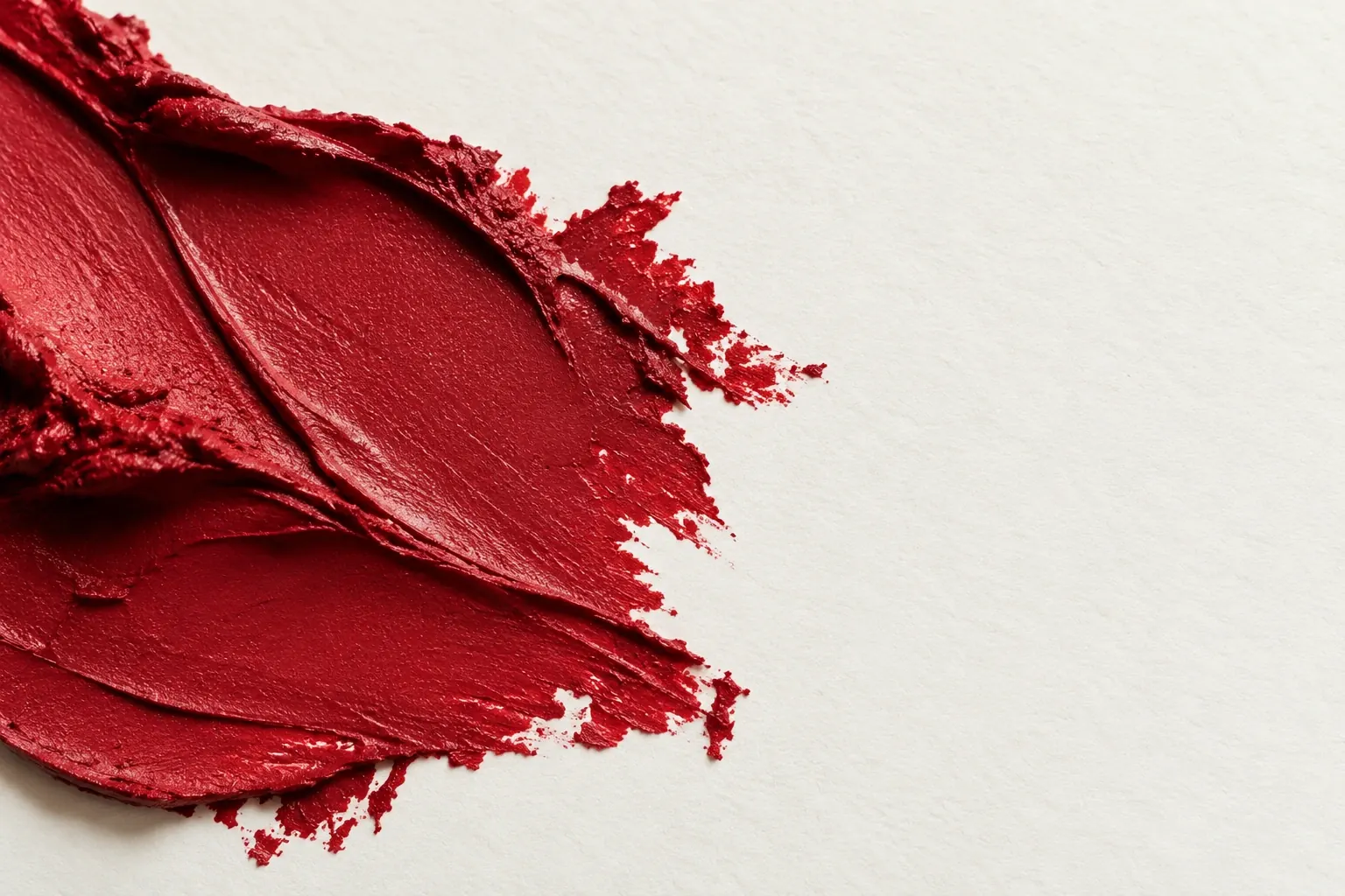 Close detail of crimson cosmetic pigment and its tactile edges on paper